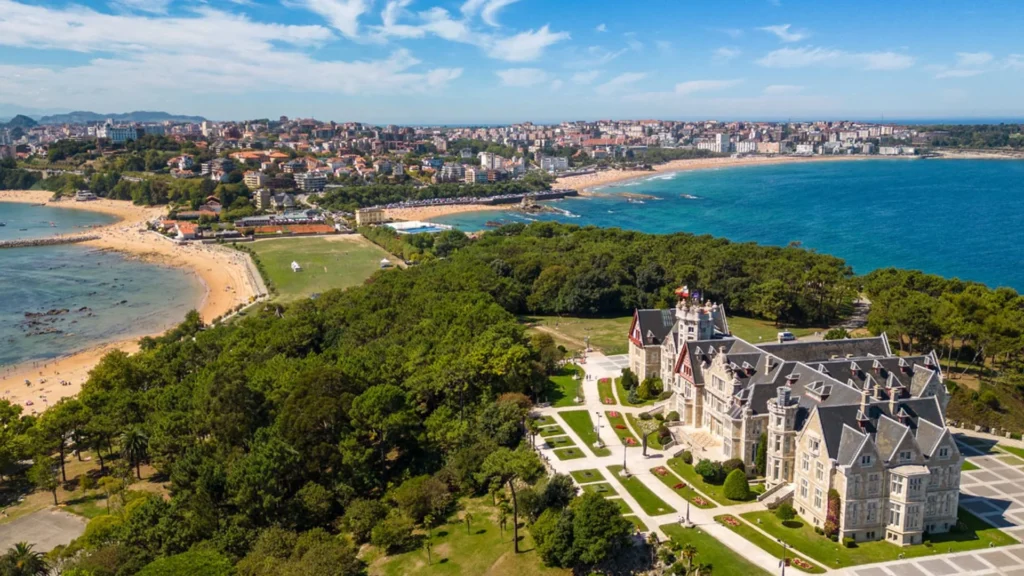 View across the formal gardens of the Palacio de la Magdalena towards the palace and the Bay of Santander, with the city and beaches beyond.