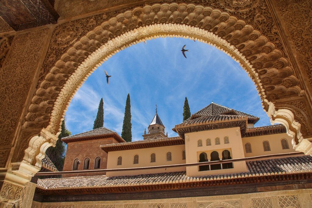 Arched window with a view from Alhambra; Granada. Credit. Pixabay.